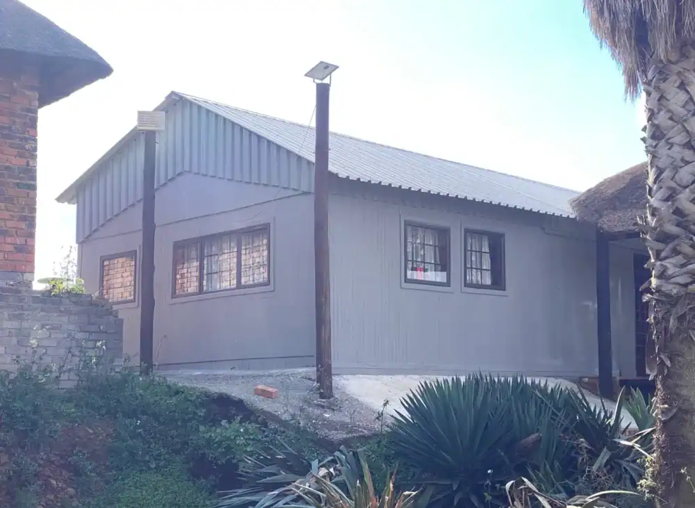 Contemporary house with metal siding, solar-powered outdoor lighting, and lush landscaping.