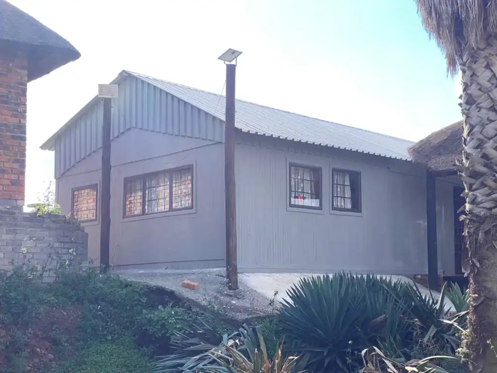 Contemporary house with metal siding, large windows, and solar-powered outdoor lighting.